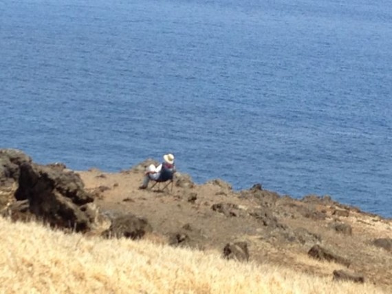 Person sitting on Maui coast overlook