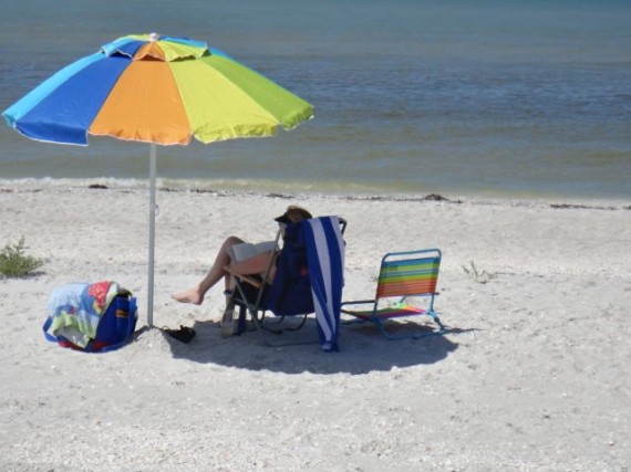 Beach umbrella and tourist on Sanibel beach