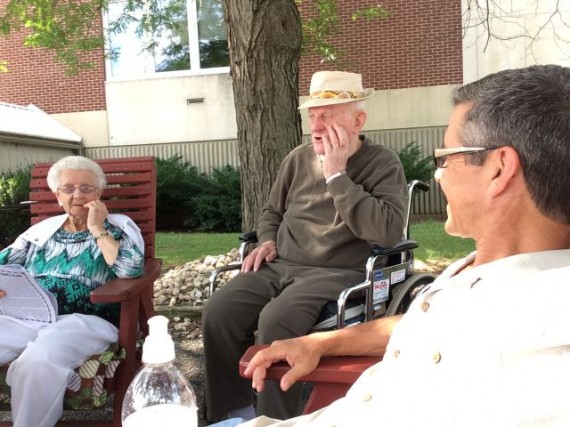 Parents and son sitting in front of Nursing home