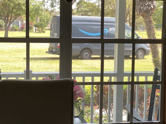 Amazon truck driving across front yard