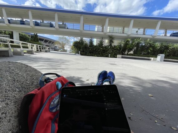 Man sitting on ground off laptop at tomorrowland