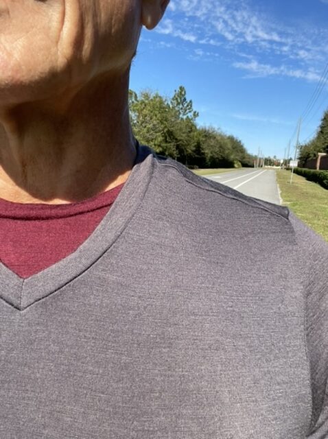 Close up of man wearing two T-shirts walking along the road