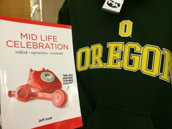 The Book, Mid Life Celebration next to U of Oregon T-shirt