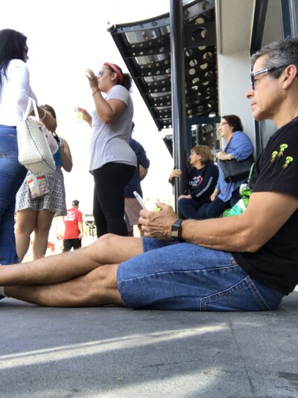 man looking at phone sitting on ground at Disney