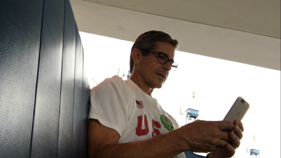 Man using iPhone while traveling on the Tomorrowland Transit Authority's PeopleMover