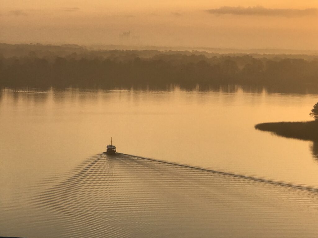 lone boat on still lake at sunrise