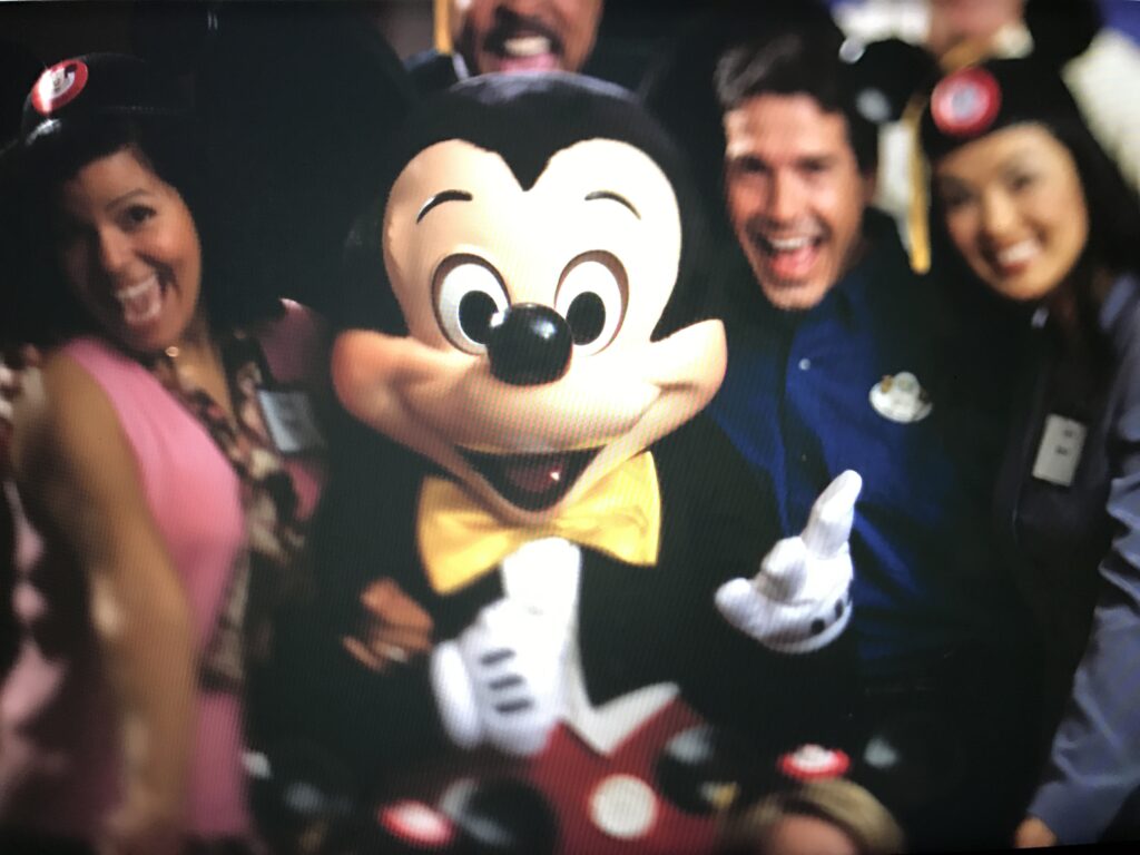 Mickey Mouse posing with three adults