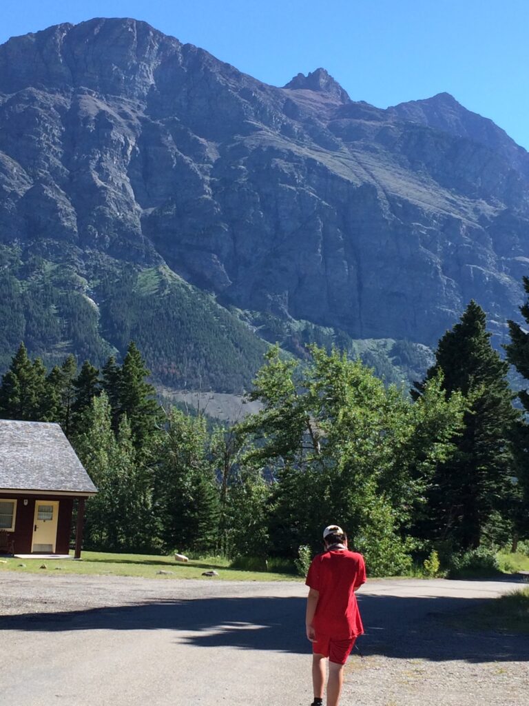 teen in red walking in the mountains