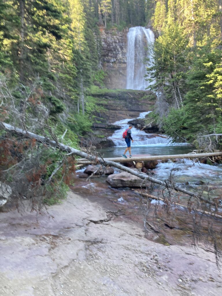 Man walking in the mountains by a waterfall