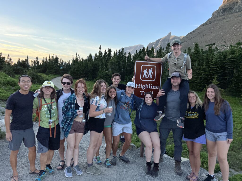 13 hikers posing for a group picture in the mountains