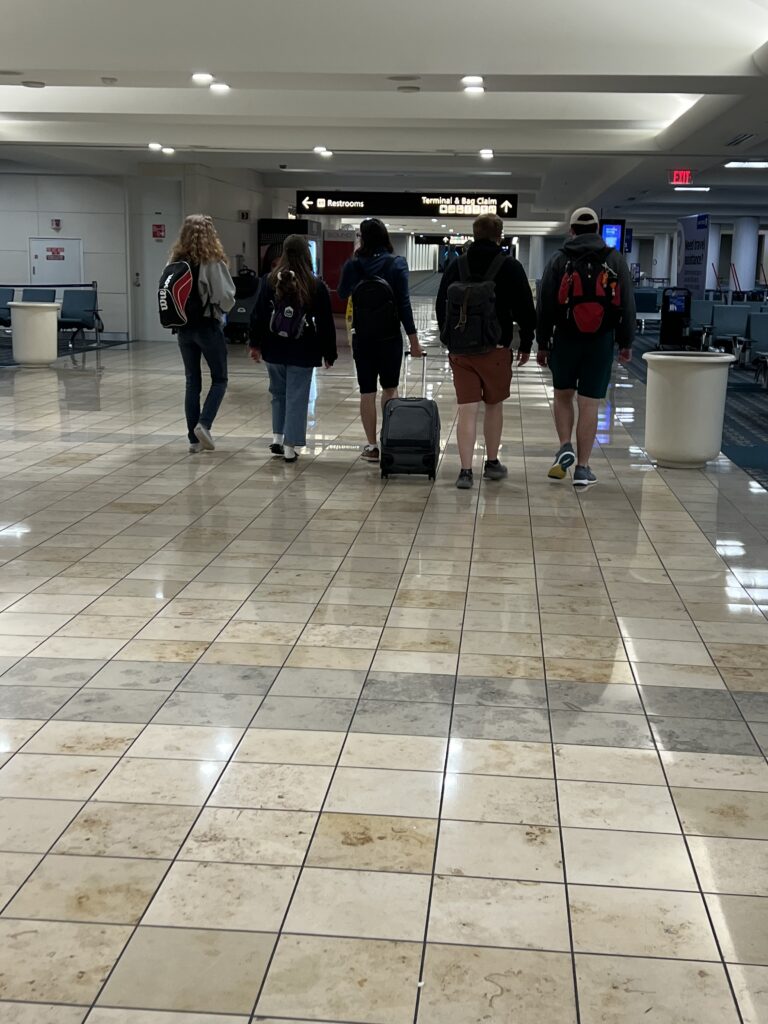 Five people walking through airport