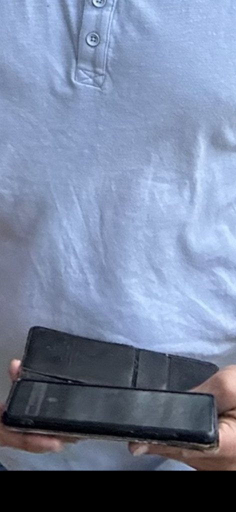 close up of a shirt being worn by a person holding a phone in both hands