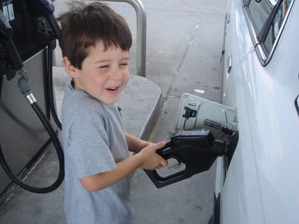 Small boy, pumping gas