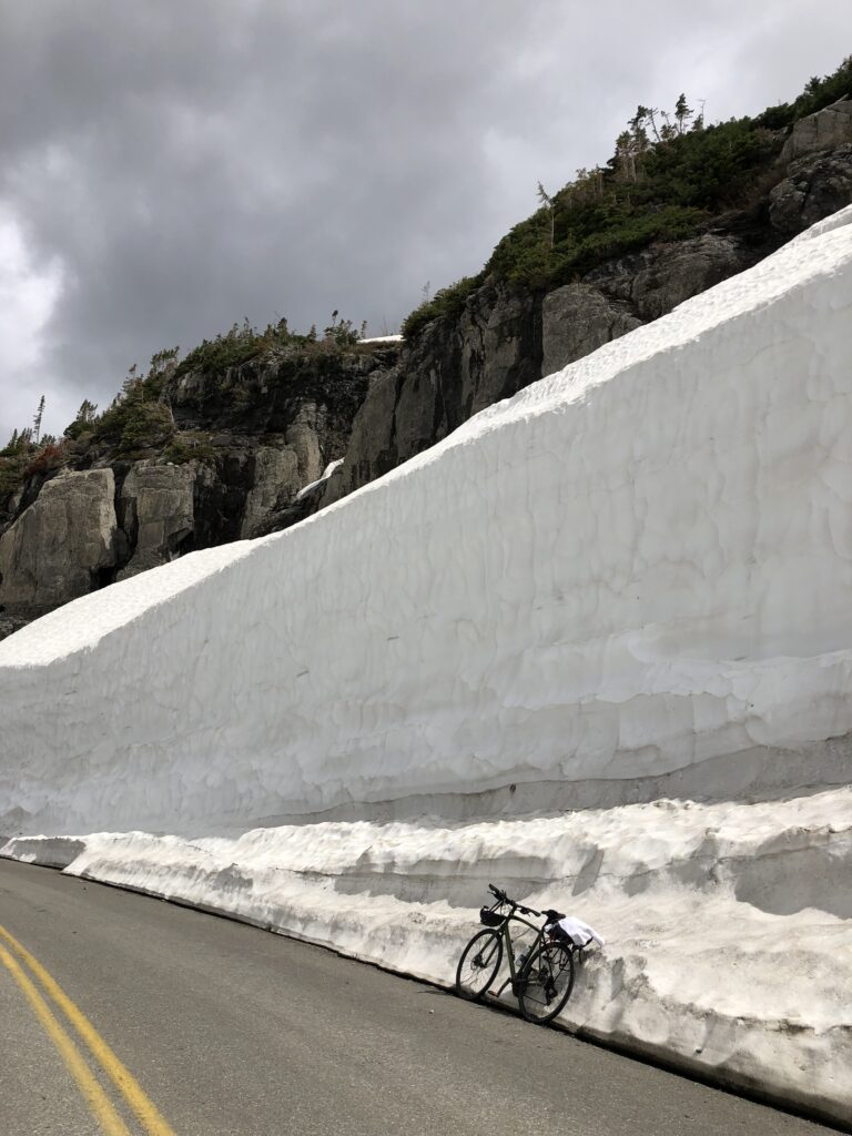 Bicycling a mountain pass road with snow drifts