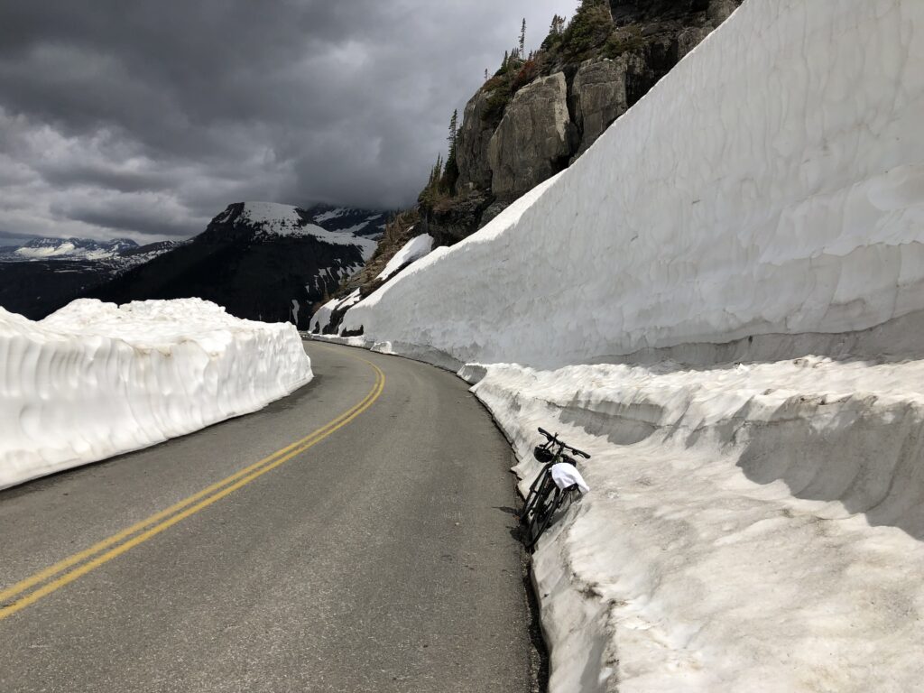 Bicycling a mountain pass road with snow drifts