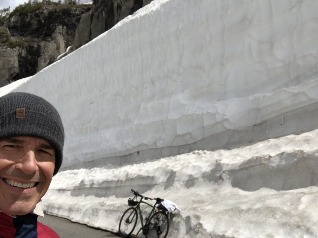 Bicycling a mountain pass road with snow drifts