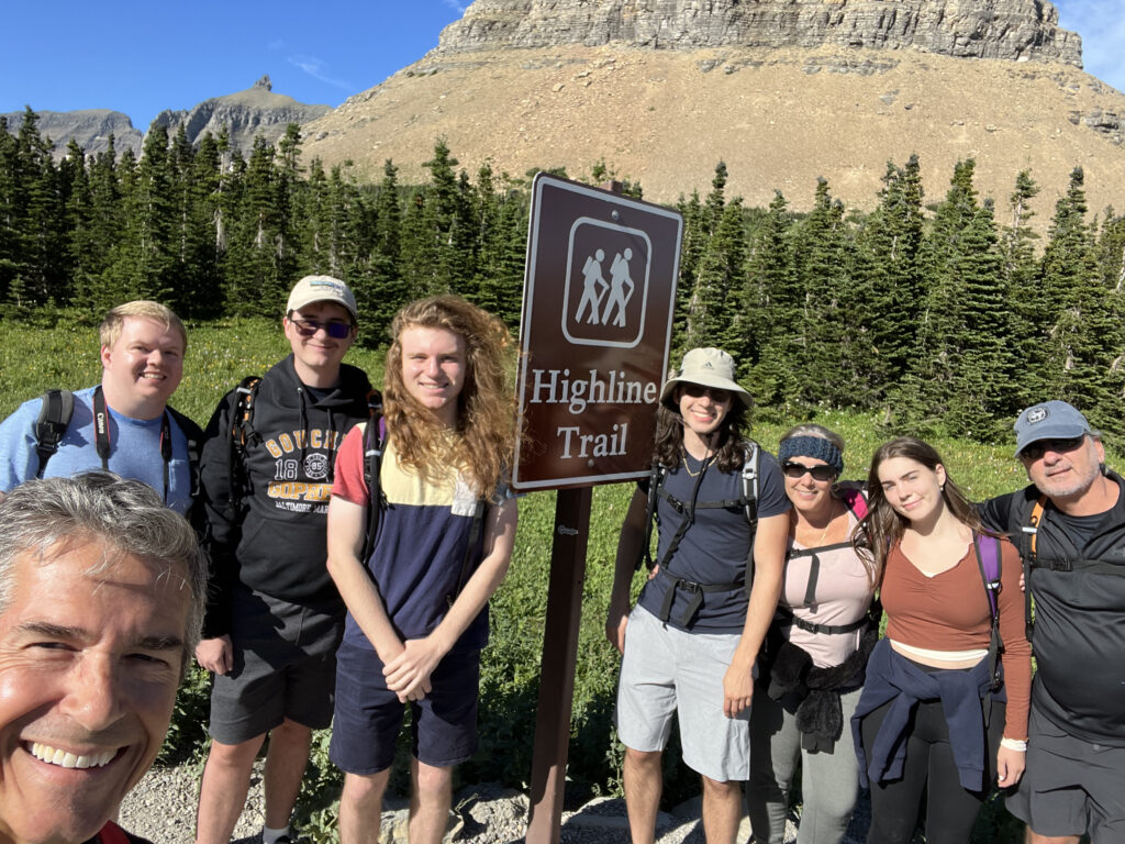 family by mountain trail sign