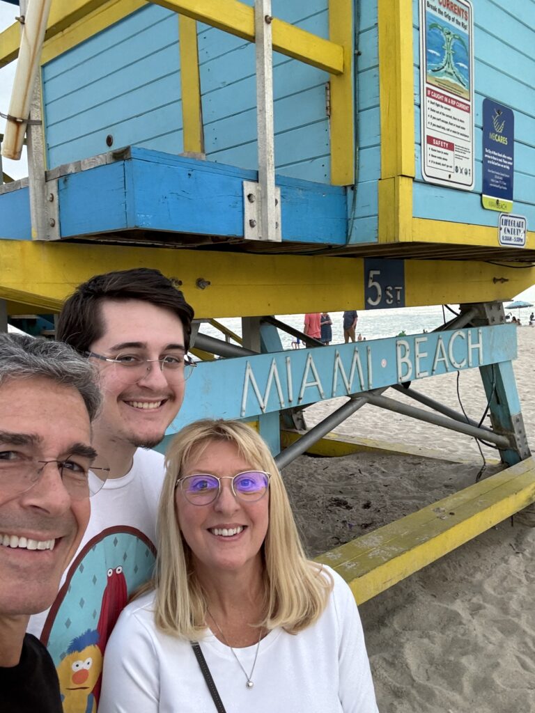 Three adults by Miami Beach lifeguard stand