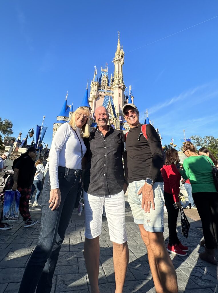 Three adults by Disney castle