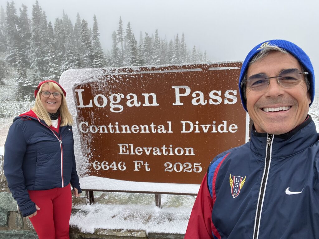 Two people by snowy national park sign