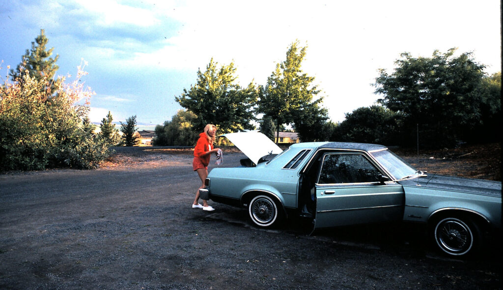 Woman next to green car