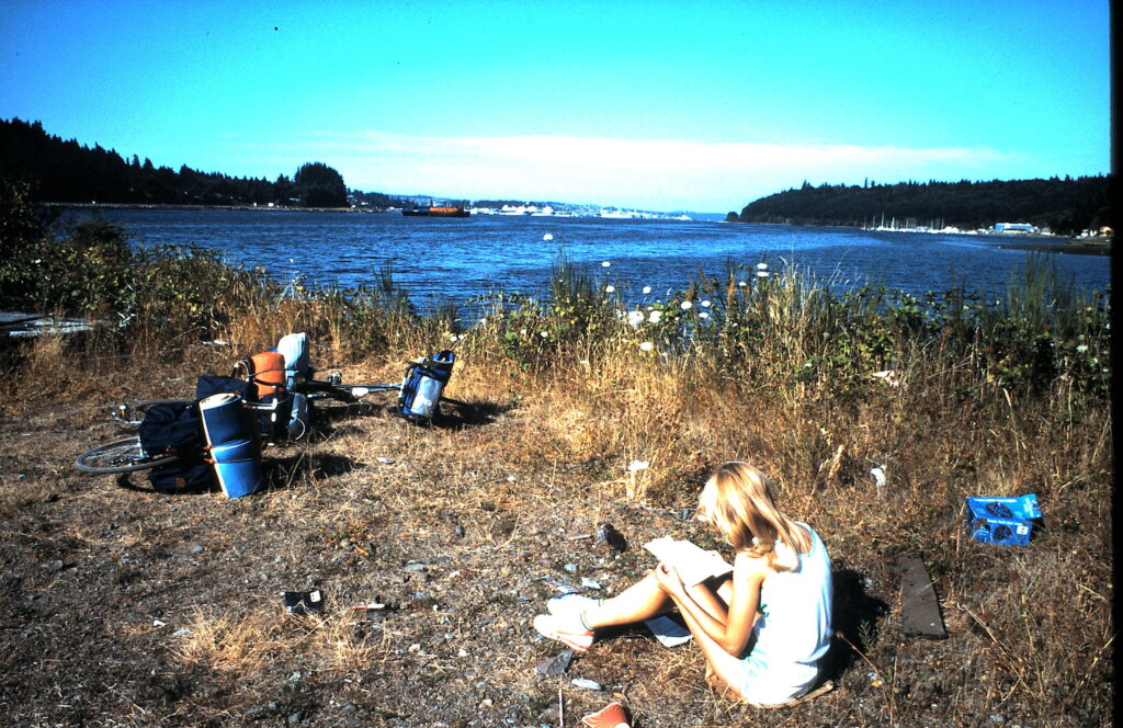 Woman sitting on the ground next to water