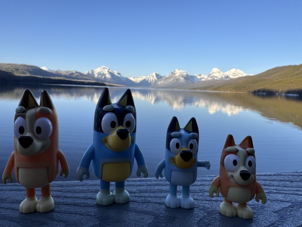 Bluey toy figurines by mountain lake