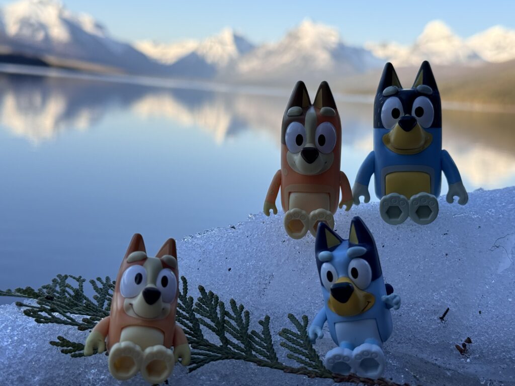 Bluey toy figurines by mountain lake