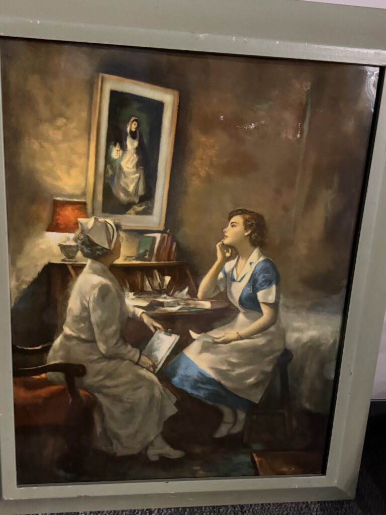 Photo of a painting with two nurses sitting bedside