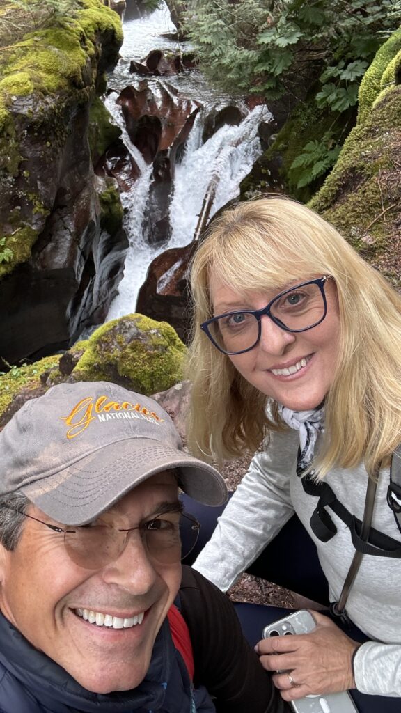 honeymoon couple next to creek water-carved mountain rock