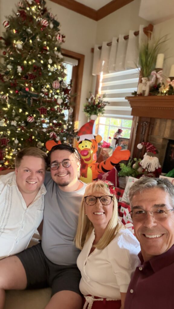 Family of four at Christmas tree