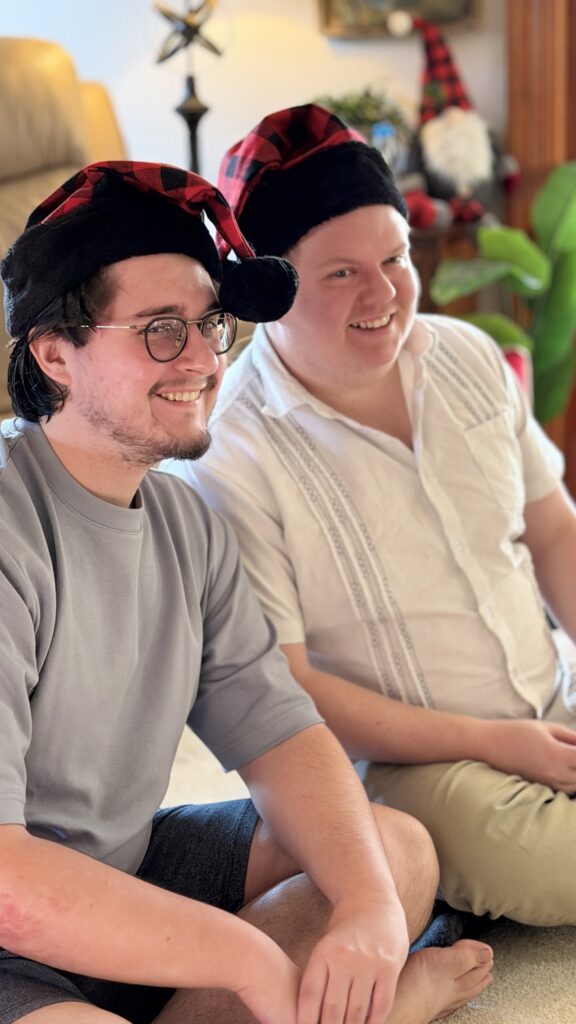 Two adults by Christmas tree