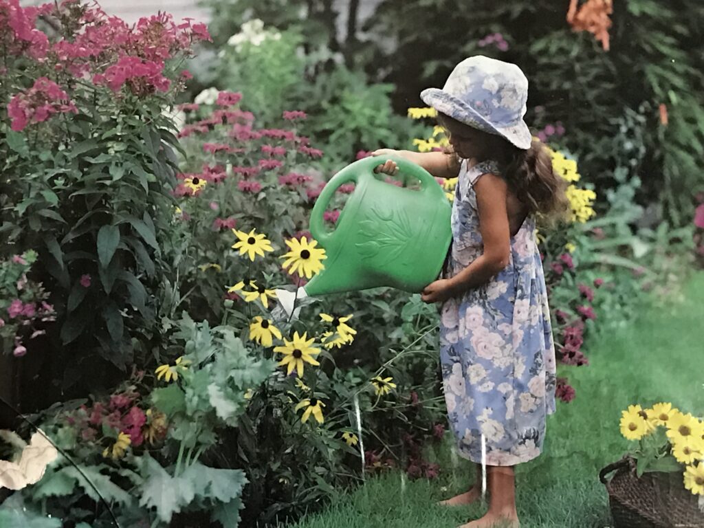 Small child watering flowers