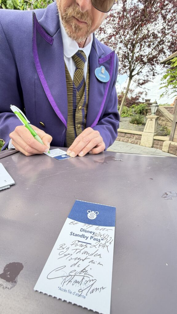 Disney cast member writing a fast pass note