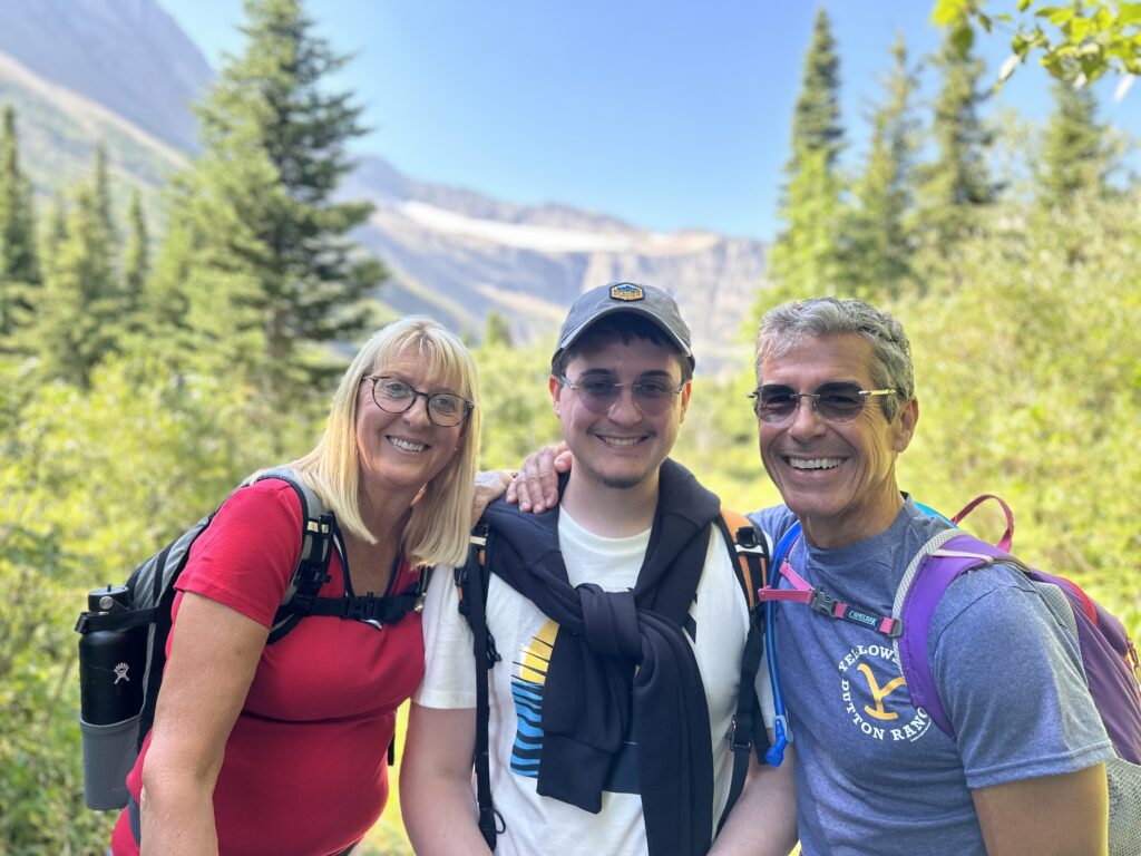 family of three posing in the mountains